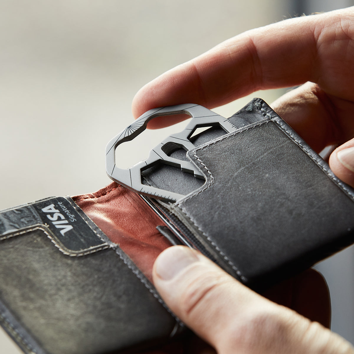 M010 credit card tool being slid into a wallet