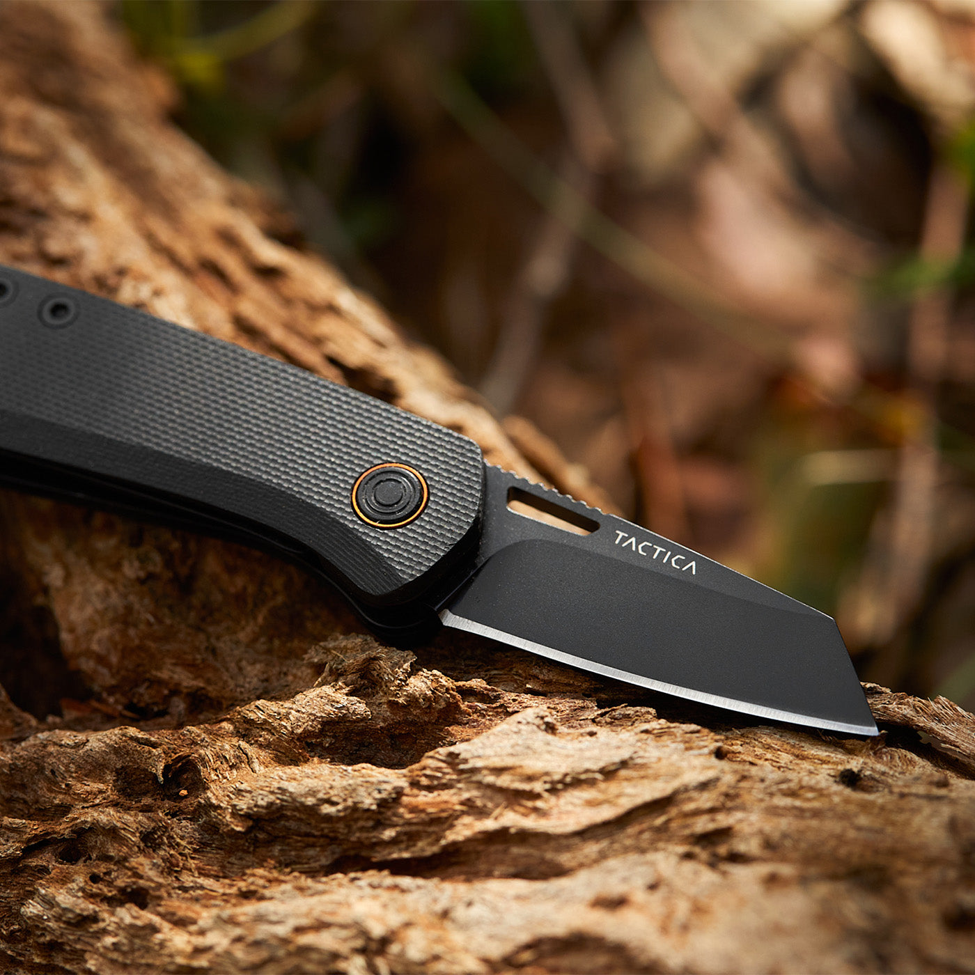 K150 micro folder with blade open against a natural background with wood