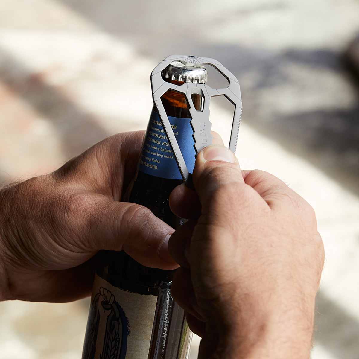 M010 credit card tool being used as a wallet bottle opener