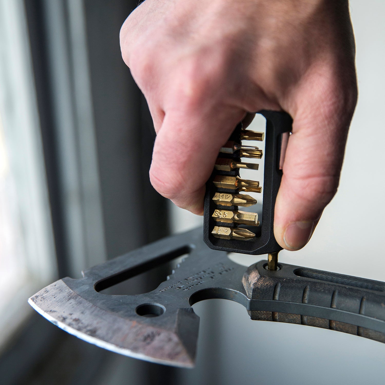 M250 hex screwdriver multitool being used to tighten the screw on a tool