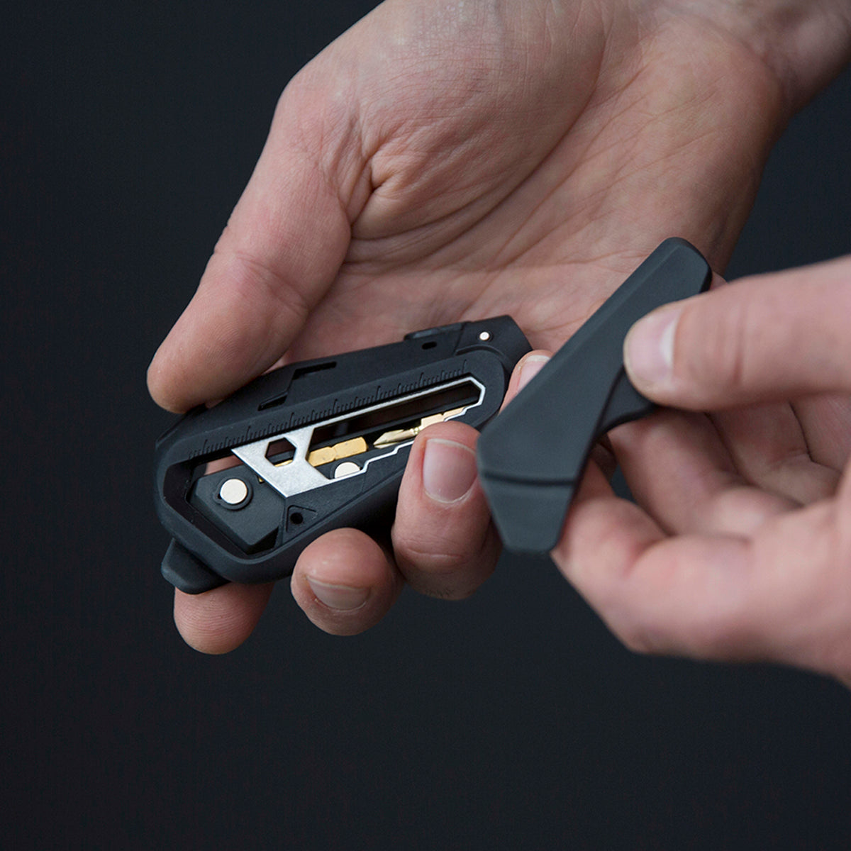 Person holding the M110 bike multitool revealing the inner storage compartment