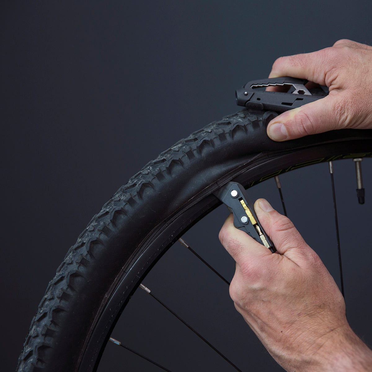 Person using the non-scratch bike lever to remove a bike wheel